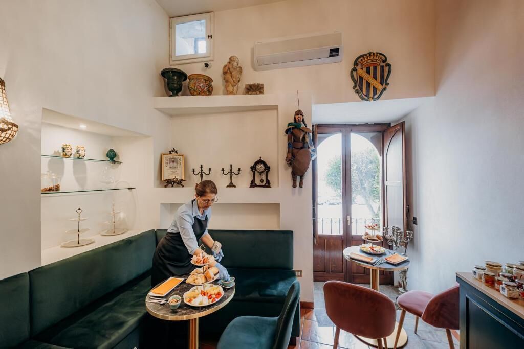 A dining area with a table, chairs, and a person serving food.
