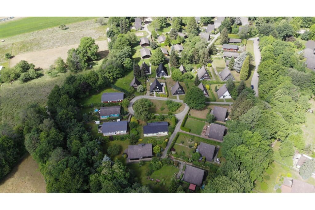 Vue aérienne d’un quartier résidentiel où les maisons sont entourées d’une végétation luxuriante.
