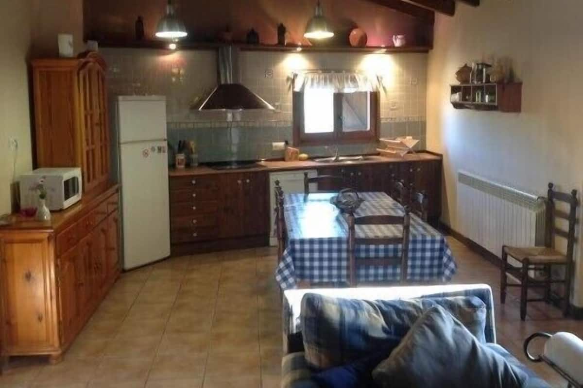 A compact kitchen with a dining table and a sofa in the living area.