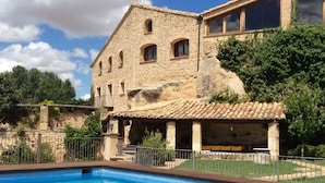 A stone building with a pool in front. - Hotel Hort De Fortunyo (Arnes)