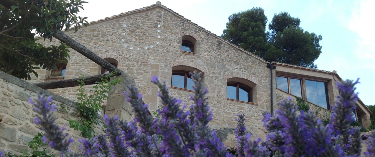 A stone building with arched windows and a balcony.