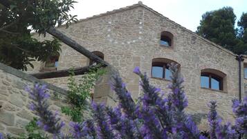 A stone building with arched windows and a balcony.