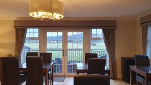 A dining area with a view of a green landscape through large windows. - Springfield Lodge B&B (Stirling)