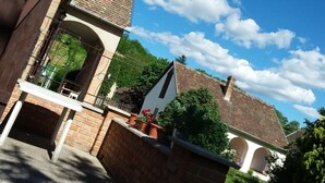 A courtyard with a brick wall, a white table, and potted plants.