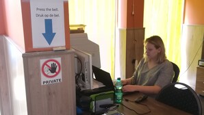 A reception desk with a sign indicating check-in times and a private notice. - Logies Waasland (Sint-Niklaas)