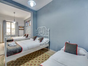 A hotel room with two beds, a large mirror, and a view of the street. - OYO Ruzafa Guesthouse (Valencia)