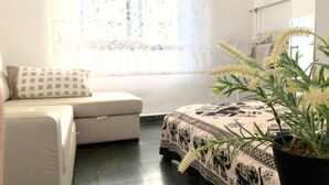 A room with a bed, a sofa, and a window with patterned curtains. - OYO Guest House Torre de Quart (Valencia)