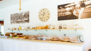 A breakfast bar with various food items and a vintage clock. - Semi detached Villa Country (Vieste)