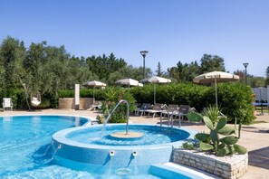 Ein Swimmingpool mit Whirlpool, Liegestühlen und Sonnenschirmen.