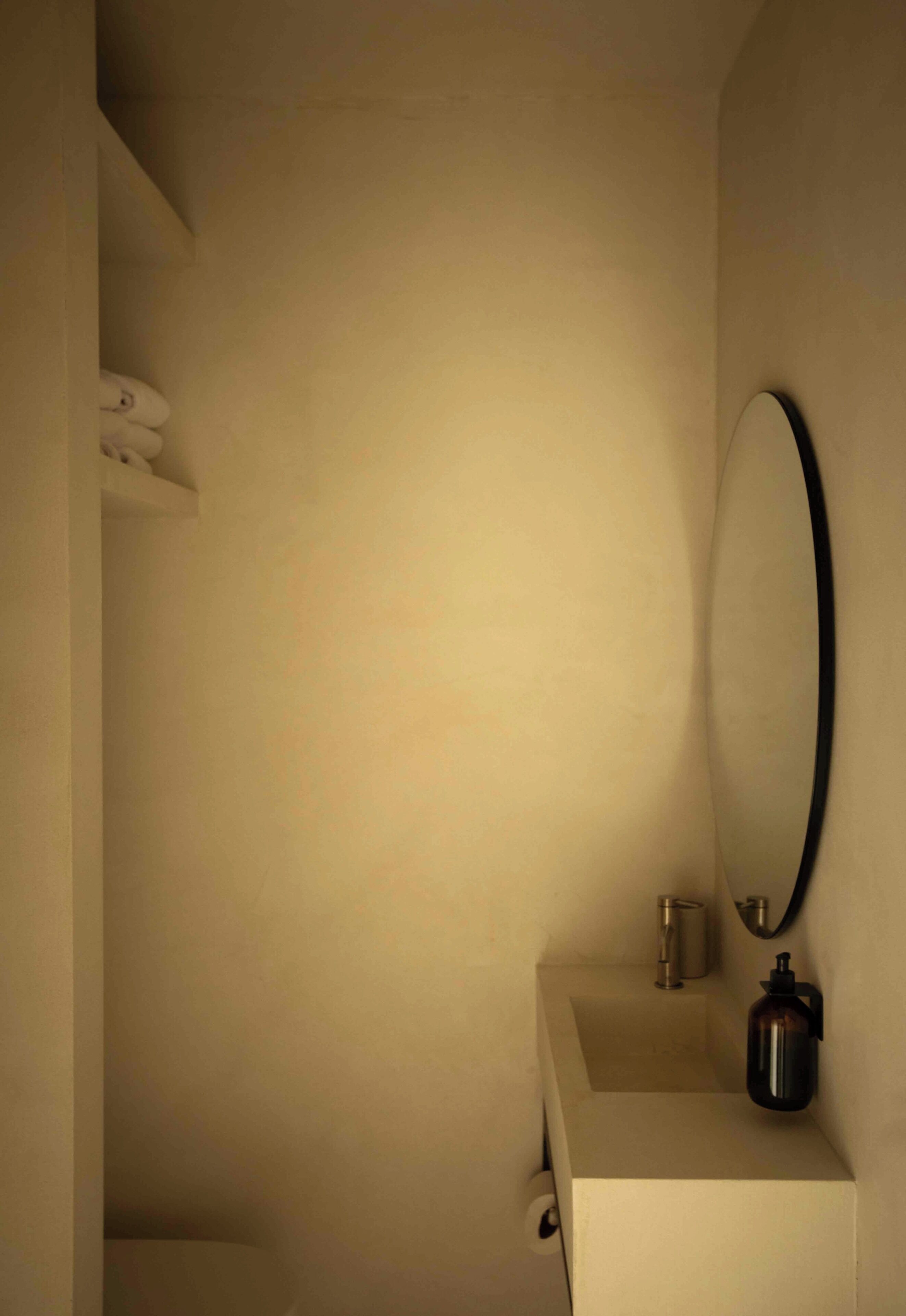 Une salle de bain avec un lavabo blanc, un miroir et une machine à café.