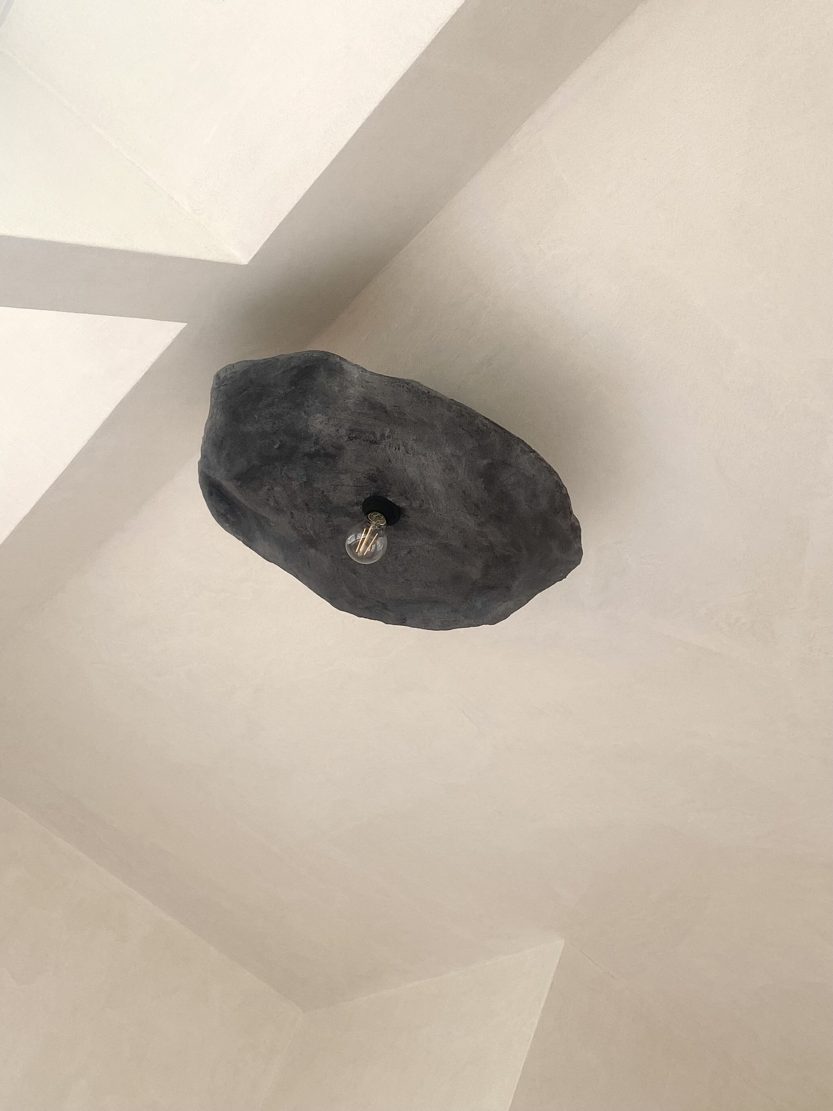 Un plafond orné d’un luminaire au design original et aux formes irrégulières.