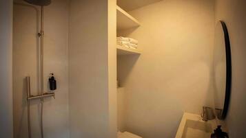 A bathroom with a shower, toilet, and sink.
