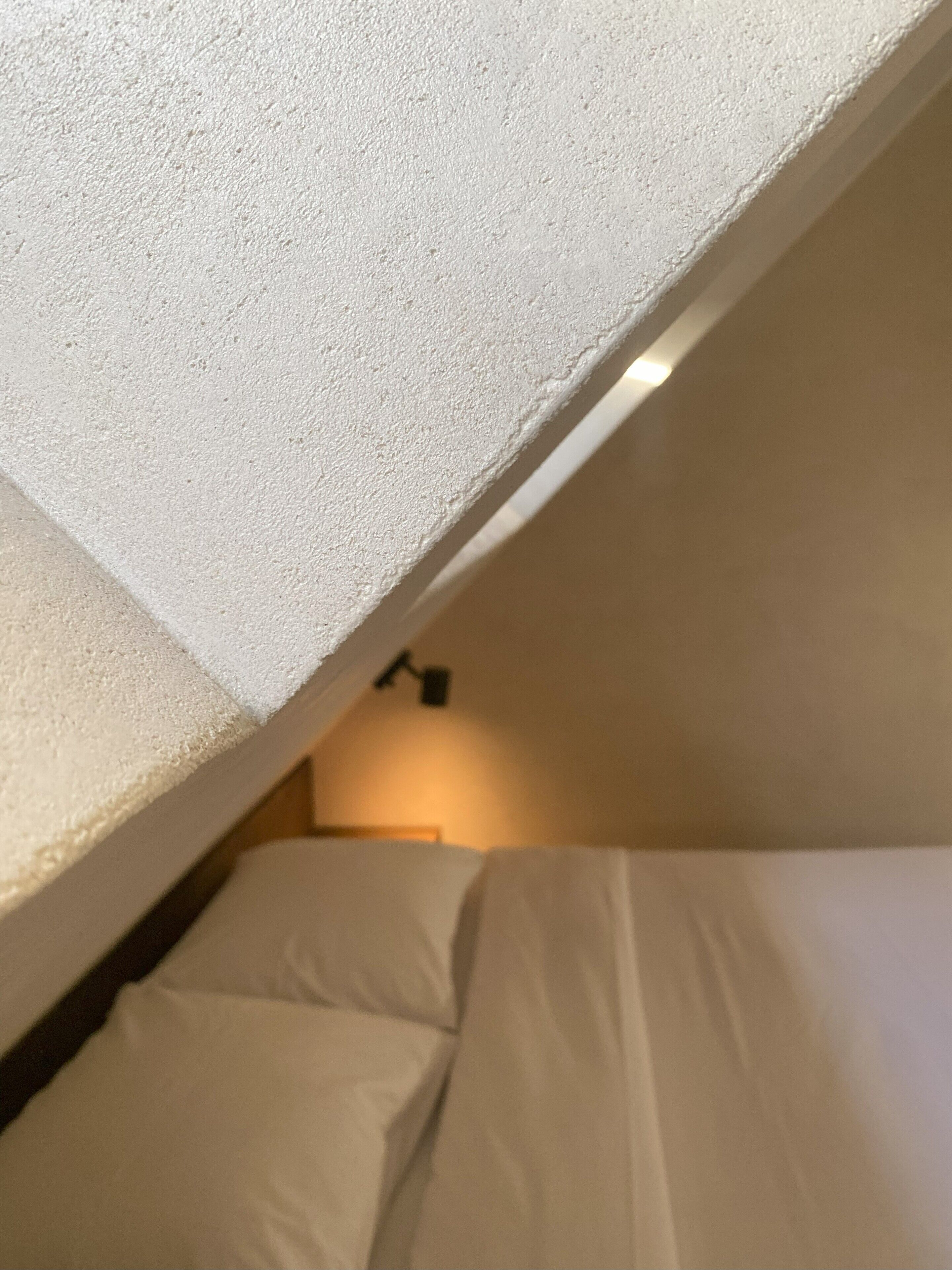 Una cama litera con ropa de cama blanca y cabecera.