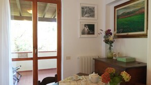 Ein Essbereich mit einem für Tee gedecktem Tisch, einem Heizkörper und einem Bild an der Wand.