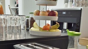 A kitchen counter with a toaster, a fruit display, and a basket of bread. - Boutique-Hotel Kronenstuben (Ludwigsburg)