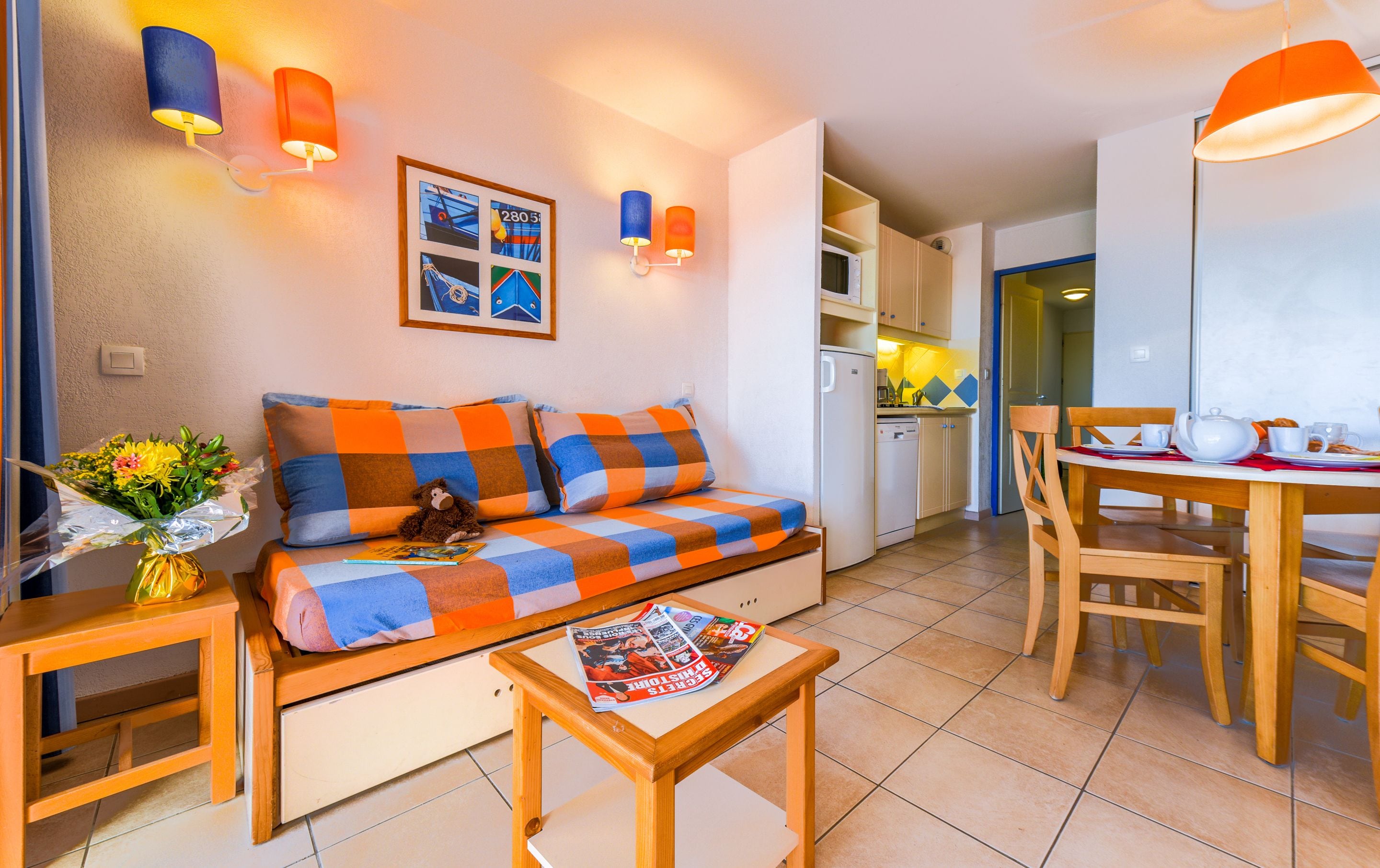 A cozy living room with a sofa, a coffee table, and a dining area with a table and chairs.