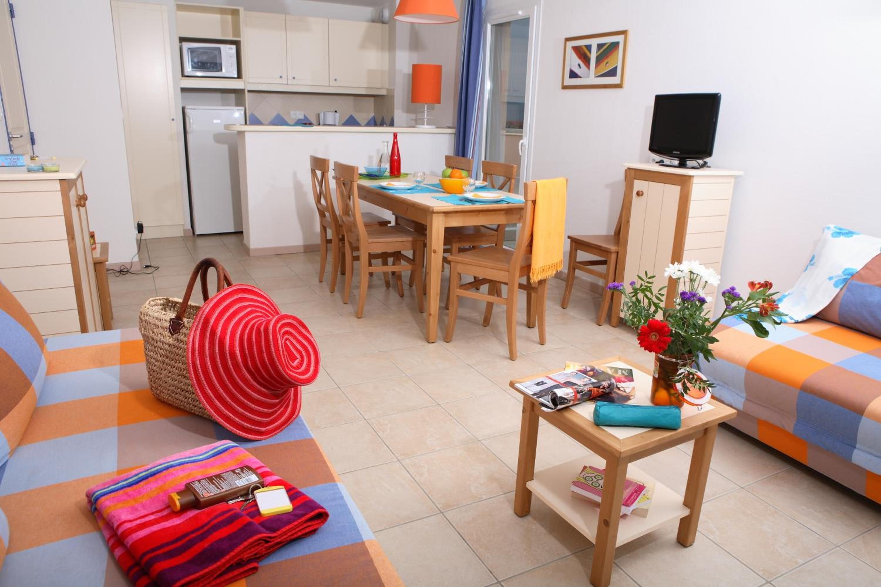 A compact living space with a dining area, kitchenette, and a sofa.