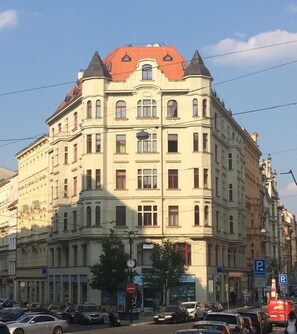 A multi-story building with a classic architectural style, featuring a prominent corner entrance and a clock on the facade.