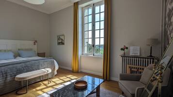 Ein helles Schlafzimmer mit einem Bett, einer Bank und einem Tisch mit einer Schale.