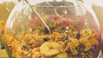 A bowl of granola with dried fruits and a spoon.