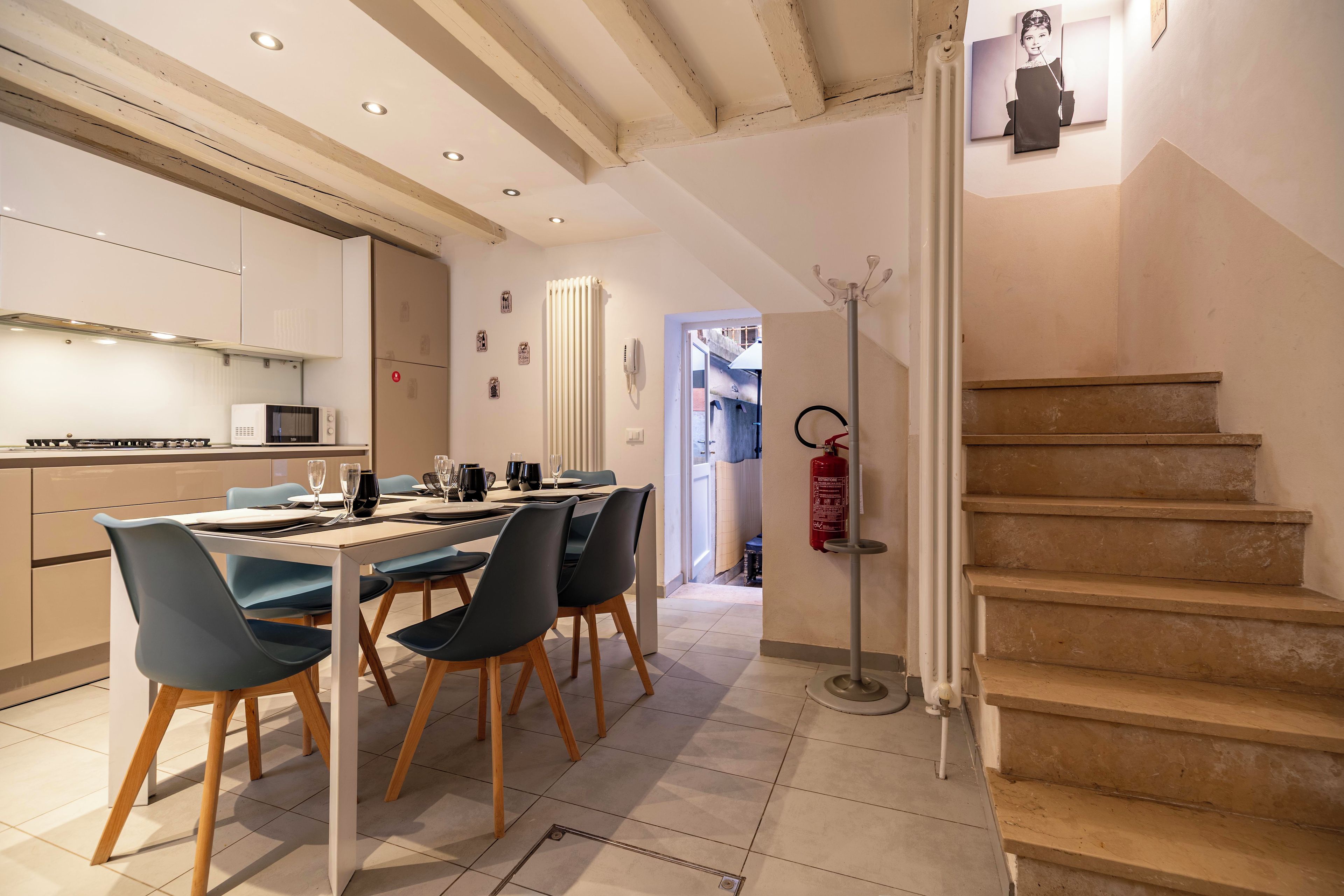 Cocina moderna con comedor, que incluye una escalera y un extintor.
