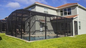A modern house with a large glass-enclosed patio area. - Paradise Palms 8950 (Kissimmee)