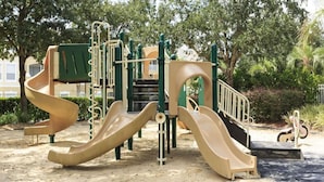 A playground with two slides and climbing structures. - 2306 Silver Palm Windsor Palms (Kissimmee)