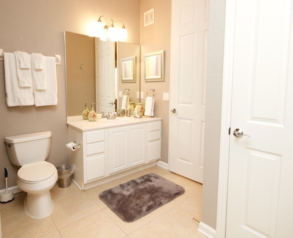 Ein Badezimmer mit Toilette, Waschbecken, Spiegel und Handtuchhalter.