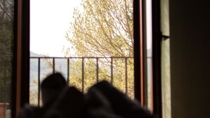 A view through a window with a balcony railing, a tree, and a body of water in the background. - Al Regio Tratturo (Manoppello)