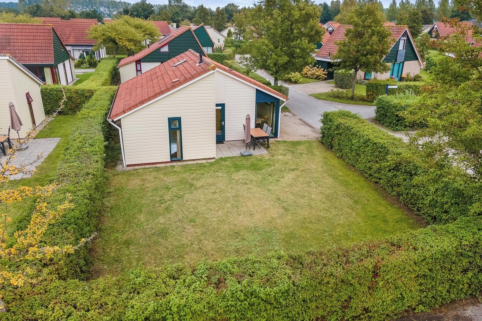 A small, single-story house with a red roof and a front porch.