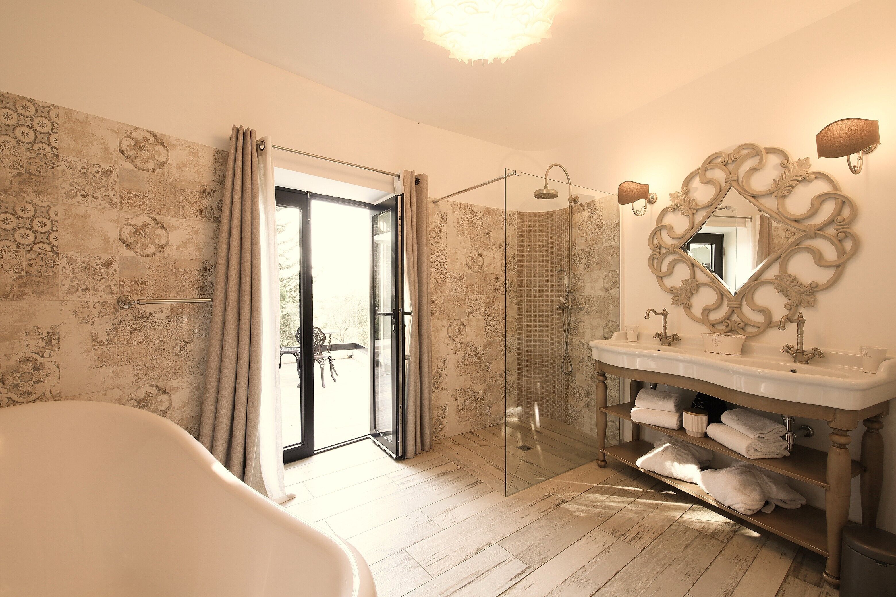 A bathroom with a bathtub, a shower, a vanity with a mirror, and a towel rack.
