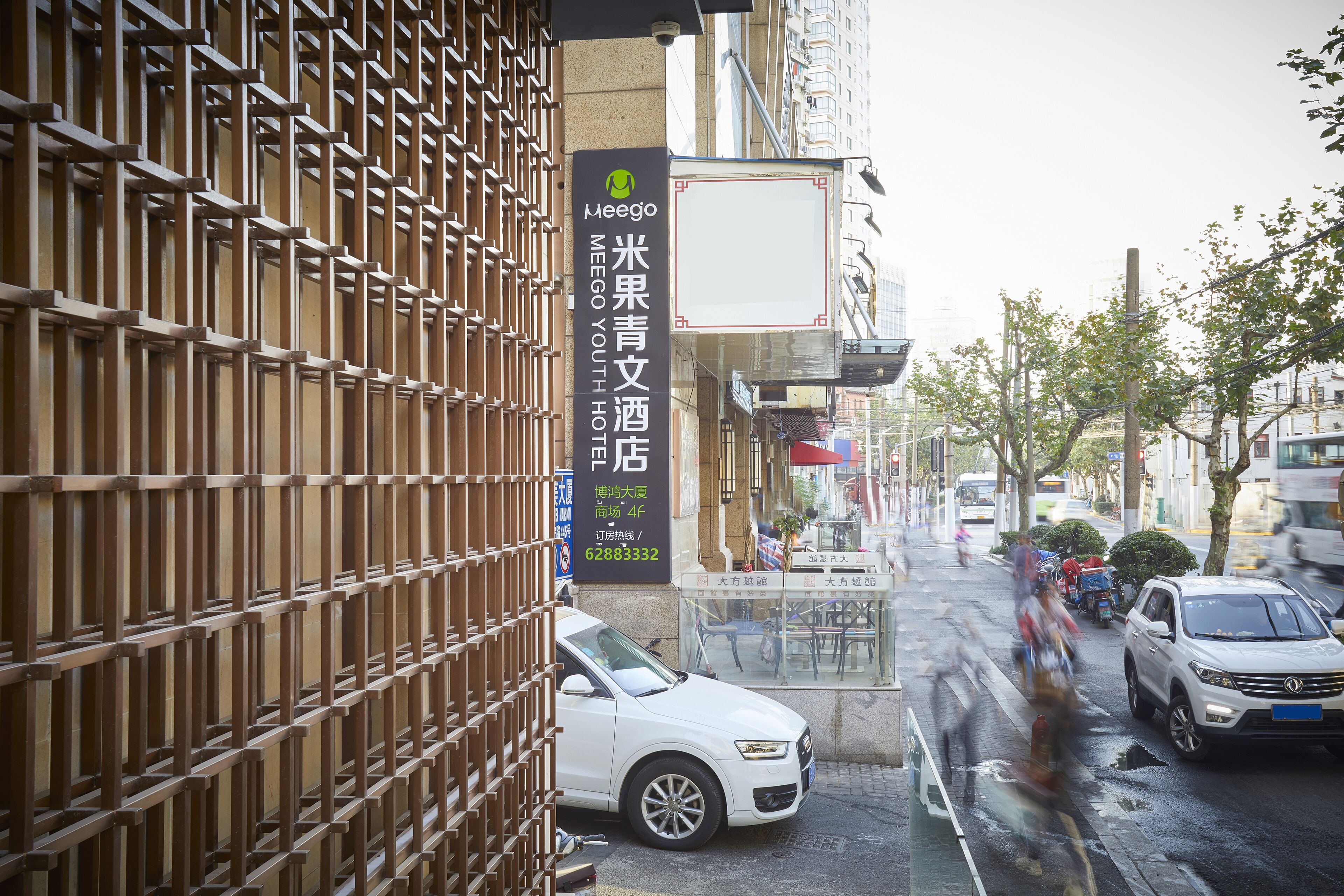 A street view with a building featuring a sign for Meego Youth Hotel.