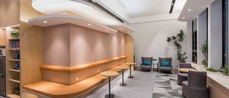 A modern waiting area with a curved bench, small tables, and seating.