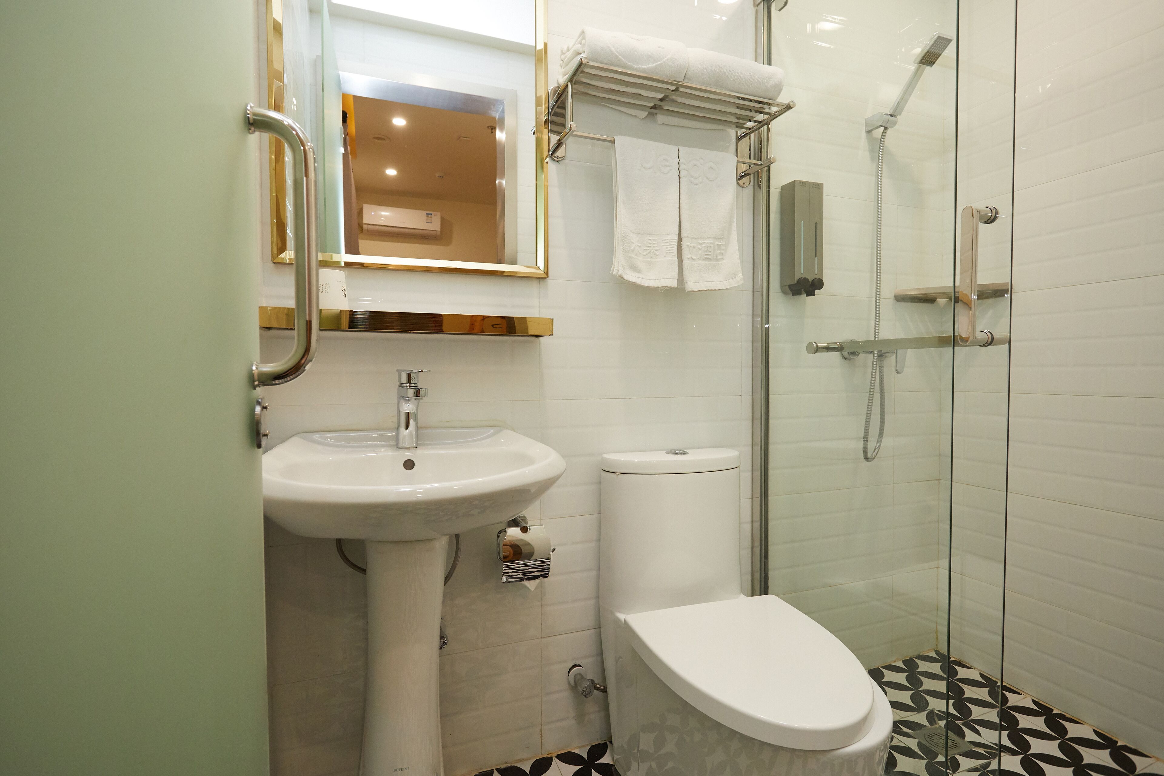 A bathroom with a sink, toilet, and glass-enclosed shower.