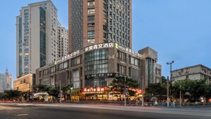 Un hotel con fachada moderna, ventanas amplias y señalización que indica que es un hotel.