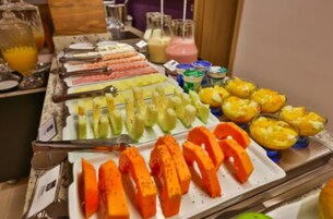 Um buffet com diversas frutas e bebidas.