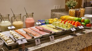A buffet with various food options including meats, cheeses, fruits, and beverages. - Maringá Airport Hotel (Maringá)