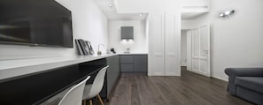 A modern kitchen with a black countertop, white chairs, and a grey cabinet. - Emilia Suite Express (Modena)