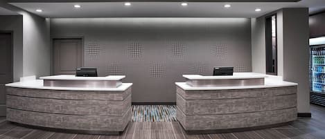 A reception area with two counters, a patterned wall, and a tiled floor.