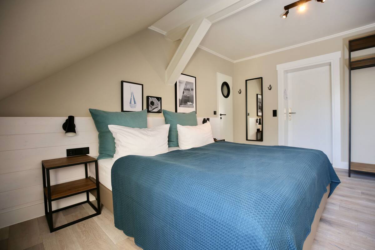 A bedroom with a bed, a nightstand, and a door.