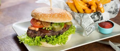 Una hamburguesa con papas fritas sobre un plato blanco.