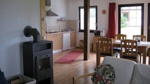 Un espacio habitable compacto con kitchenette, zona de comedor y sofá.