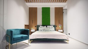 Ein modernes Schlafzimmer mit einem Bett, einem blauen Sessel, Holzwandverkleidung und einem vertikalen Grünpflanzenwand.