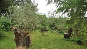 A rustic outdoor area with a wooden bench, a tree stump, and a small table. - Lilla - Two Bedroom Apartment, Sleeps 6 (Poggibonsi)