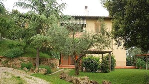 A house with a stone wall, a wooden pergola, and a garden with a gravel path. - Lilla - Two Bedroom Apartment, Sleeps 6 (Poggibonsi)