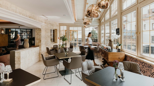 Un café spacieux avec de hauts plafonds, de grandes fenêtres et un mobilier moderne.