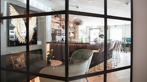 Un intérieur moderne comprenant un bar, des espaces pour s’asseoir et une grande statue ailée décorative.