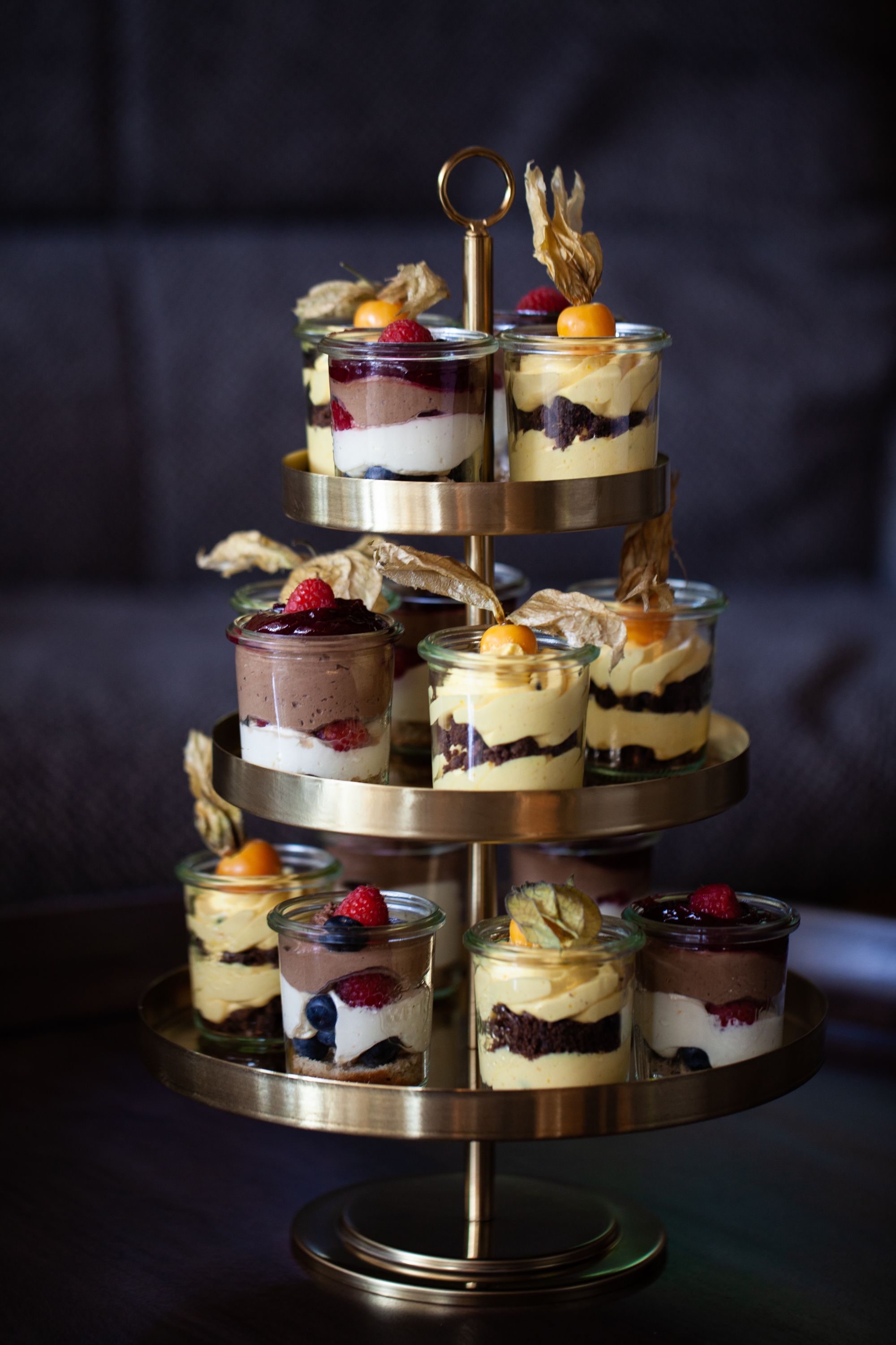 A multi-tiered dessert stand with various layered desserts.