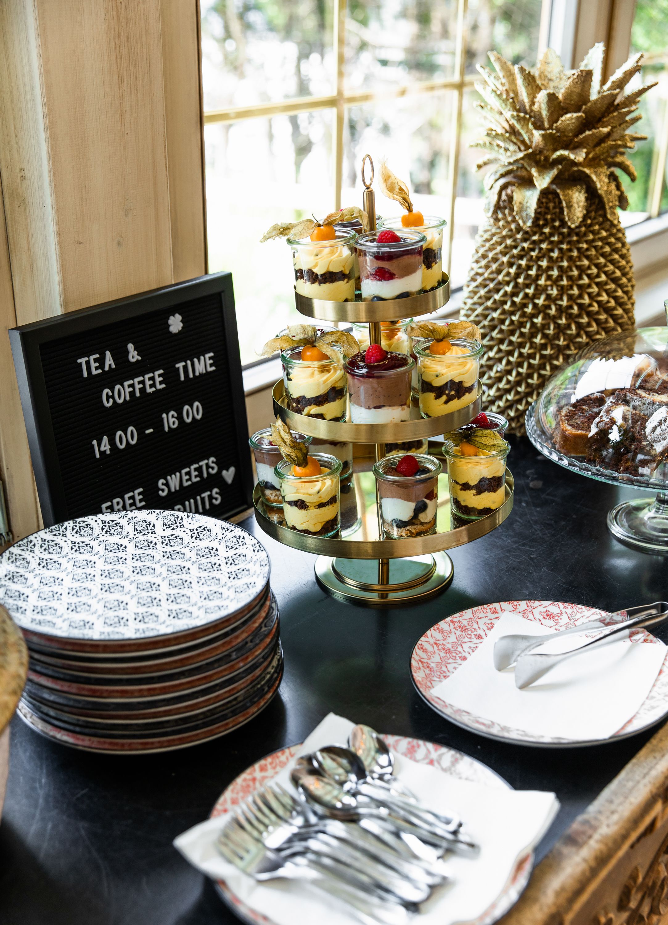 Een presentatie van desserts met een bordje dat thee en koffie aangeeft.