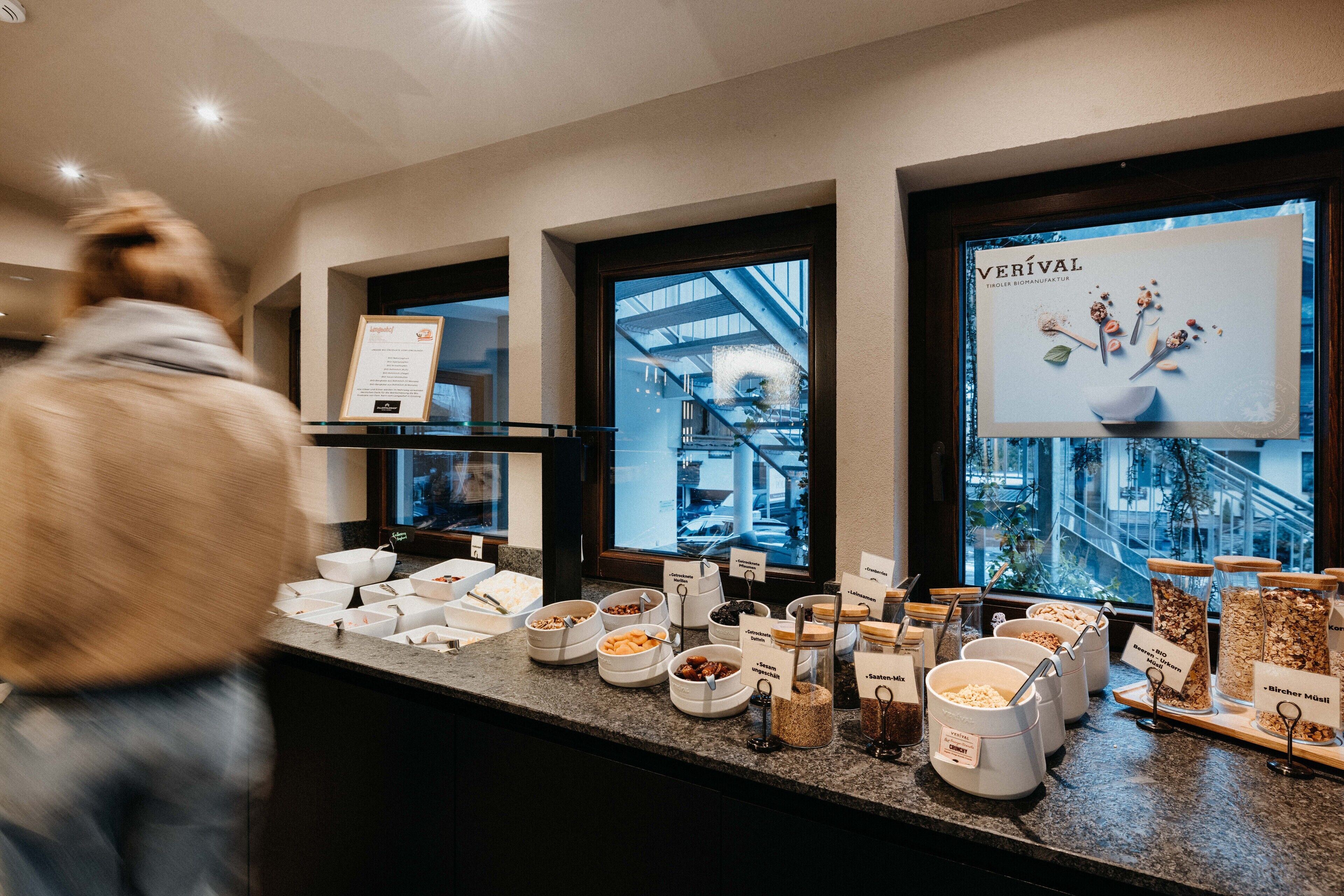 A buffet counter with various food items and a sign for Verival.